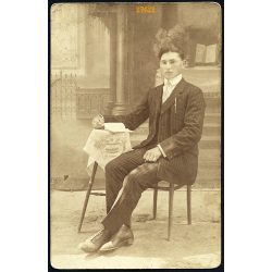   Tóth műterem, Lajosmizse, 1920-as évek, fiú csíkos öltönyben könyvvel, különös (szabadtéri ?) vidéki műterem földes padlóval, festett háttérrel. Eredeti fotó, papírkép.  