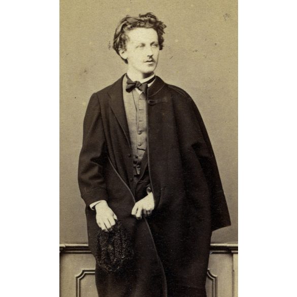 Borsos és Doctor műterem, Pest, fiatal férfi köpenyben, csokornyakkendő, kucsma, sapka, csizma, monarchia, 1860-as évek, Eredeti CDV, vizitkártya fotó.   