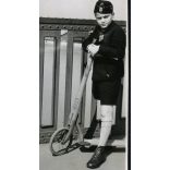 Fiú Steiff fa rolleren, Budapest, Horthy (Petőfi) híd, városkép, játék, jármű, közlekedés, levente (?) egyenruha, Horthy-korszak, 1939, 1930-as évek, helytörténet. Eredeti fotó, papírkép, hátulján rag