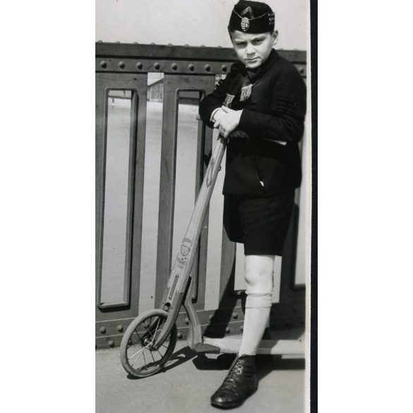 Fiú Steiff fa rolleren, Budapest, Horthy (Petőfi) híd, városkép, játék, jármű, közlekedés, levente (?) egyenruha, Horthy-korszak, 1939, 1930-as évek, helytörténet. Eredeti fotó, papírkép, hátulján rag