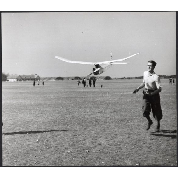 Nagyobb méret, Szendrő István fotóművészeti alkotása, robbanómotoros repülőgépmodellel a reptéren, 1930-as évek. Eredeti, pecséttel jelzett fotó, papírkép, Agfa Brovira papíron. 