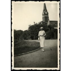   Elegáns nő kalapban, Arad, Erdély, háttérben a Vörös Templom, evangélikus templom, egyház, utcakép, Horthy-korszak, helytörténet, 1930-as évek, Eredeti fotó, papírkép, hátulján ragasztásnyomok. 