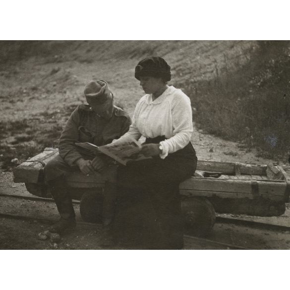 Magyar katona újságot olvas a kisvasút tehervagonján, egyenruha, 1. világháború, monarchia, jármű, közlekedés, vonat, 1910-es évek, Eredeti fotó, hátulján feliratozott papírkép.   