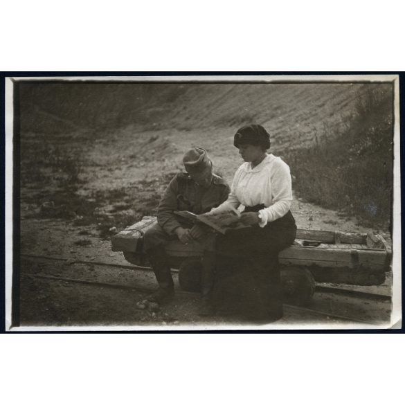 Magyar katona újságot olvas a kisvasút tehervagonján, egyenruha, 1. világháború, monarchia, jármű, közlekedés, vonat, 1910-es évek, Eredeti fotó, hátulján feliratozott papírkép.   