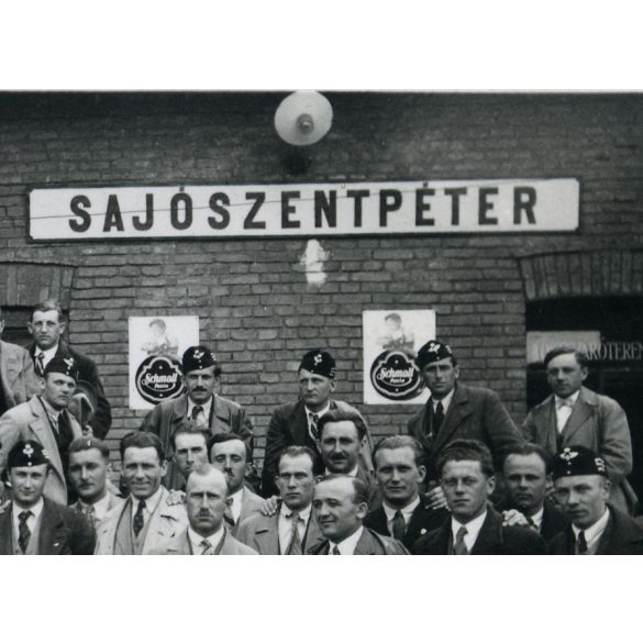 Csoportkép a vasútállomáson, Sajószentpéter, Schmoll reklám, civil férfiak vasutas (?) sapkában, közlekedés, Borsod-Abaúj-Zemplén megye,  Horthy korszak, helytörténet, 1940-es évek, Eredeti fotó, papí