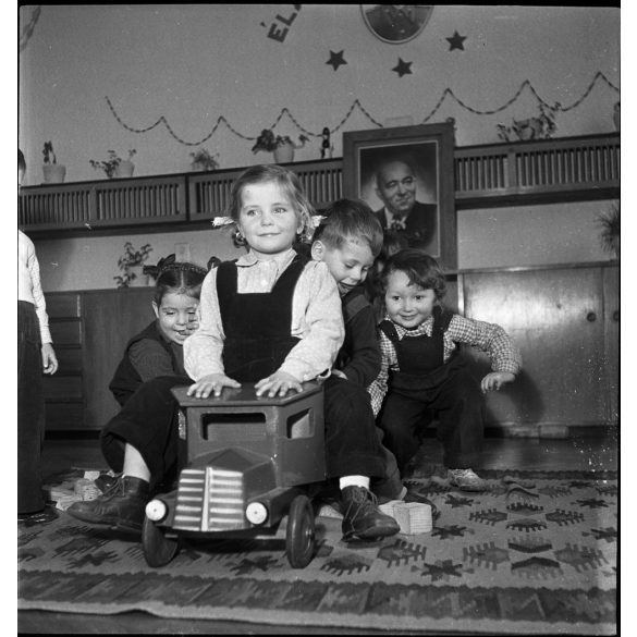 Kotnyek Antal fotóriporter munkája,  lelkes óvodások, mögöttük Rákosi Mátyás fotója, játék fa kisteherautó,  kommunizmus, 1950-es évek,  Eredeti jelzetlen, nagyméretű fotó negatív!   