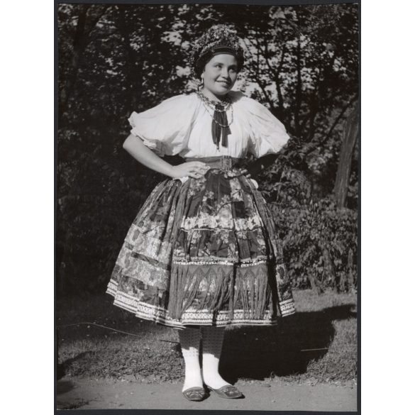 Nagyobb méret, Szendrő István fotóművészeti alkotása, fiatal lány, őcsényi (Tolna megye) népviseletben, szoknya, nyaklánc, fejfedő, 1930-as évek. 