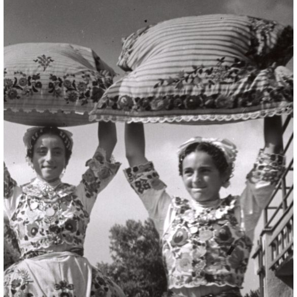 Nagyobb méret, Szendrő István fotóművészeti alkotása, lányok homokmégyi népviseletben, díszes párnákkal, Gyöngyösbokréta mozgalom, Homokmégy, Bács-Kiskun megye, népviselet, szoknya, kendő, 