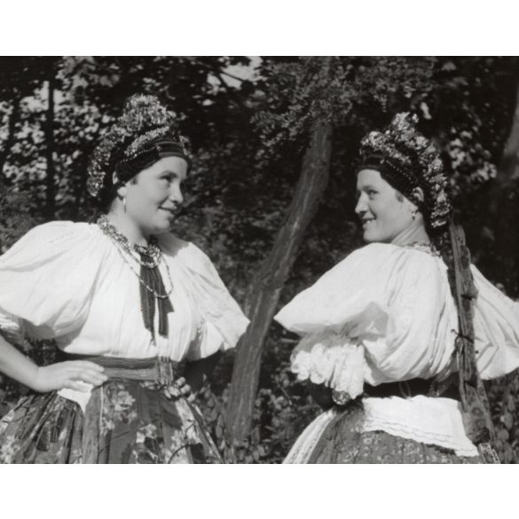 Nagyobb méret, Szendrő István fotóművészeti alkotása, fiatal lányok őcsényi népviseletben, Gyöngyösbokréta mozgalom, Őcsény, Tolna megye, népviselet, szoknya, fejdísz, kendő, 1930-as évek. 