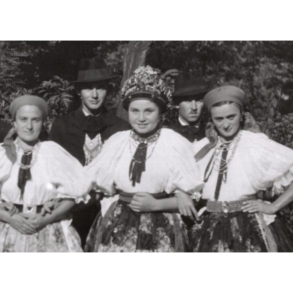 Nagyobb méret, Szendrő István fotóművészeti alkotása, fiatalok őcsényi népviseletben, Gyöngyösbokréta mozgalom, Őcsény, Tolna megye, csoportkép, népviselet, kalap, kendő, szoknya, 1930-as évek. 