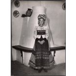 Nagyobb méret, Szendrő István fotóművészeti alkotása, matyó lány mezőkövesdi népviseletben a kályha előtt, Gyöngyösbokréta mozgalom, népviselet, fejdísz, korsó, tányér, szoknya, minta, 1930-as évek. E