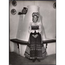   Nagyobb méret, Szendrő István fotóművészeti alkotása, matyó lány mezőkövesdi népviseletben a kályha előtt, Gyöngyösbokréta mozgalom, népviselet, fejdísz, korsó, tányér, szoknya, minta, 1930-as évek. E