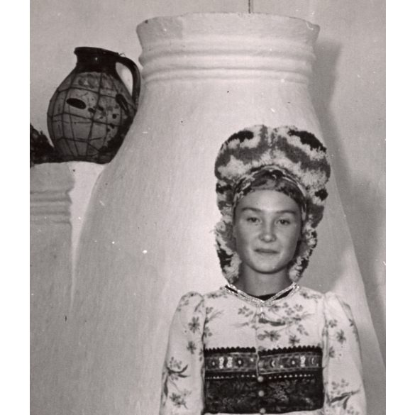 Nagyobb méret, Szendrő István fotóművészeti alkotása, matyó lány mezőkövesdi népviseletben a kályha előtt, Gyöngyösbokréta mozgalom, népviselet, fejdísz, korsó, tányér, szoknya, minta, 1930-as évek. E