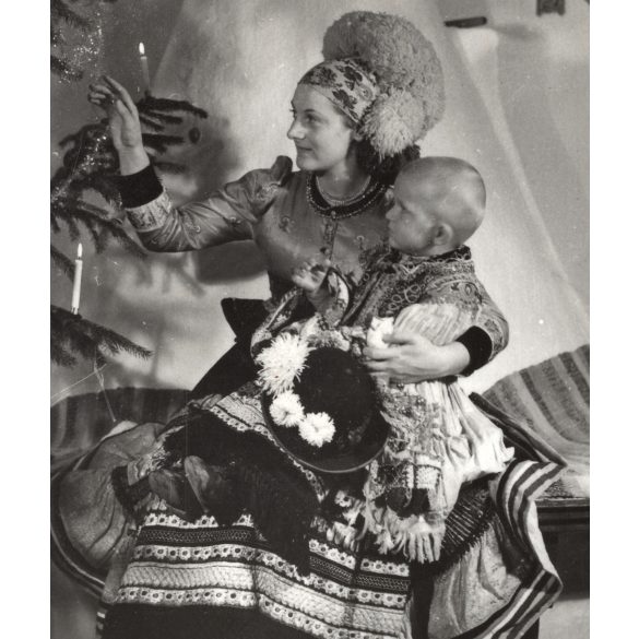 Anyuka a gyermekével matyó népviseletben, Mezőkövesd, karácsonyfa díszítés, kályha Magyarország, Horthy-korszak, népviselet, fejdísz, szoknya, helytörténet, 1930-as évek, Eredeti fotó, papírkép.  