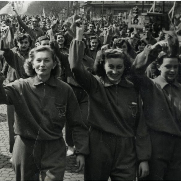 Nagyobb méret, KELTEX-es fiatal munkáslányok vonulnak. Budapest, November 7.-e tér (Oktogon), a felszabadulás 7. évfordulója, felvonulás, neon reklámok, kommunizmus, ünnep, 1952. április 4., 1950-es évek, Eredeti fotó, hátulján feliratozott papírkép,