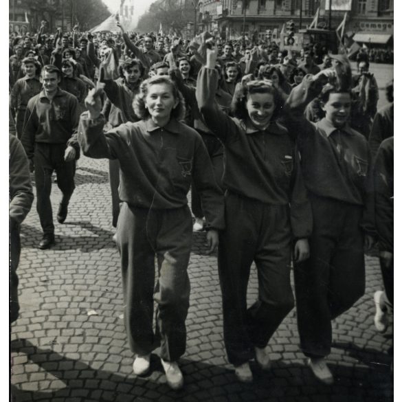Nagyobb méret, KELTEX-es fiatal munkáslányok vonulnak. Budapest, November 7.-e tér (Oktogon), a felszabadulás 7. évfordulója, felvonulás, neon reklámok, kommunizmus, ünnep, 1952. április 4., 1950-es évek, Eredeti fotó, hátulján feliratozott papírkép,