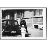 Anyuka kislánnyal, Austin Mini Van Countryman autó, Budapest, (XIII., Gergely Győző utca 17). jármű, közlekedés, helytörténet, Újlipótváros, szocializmus, személygépkocsi, 1970-es évek, Eredeti fotó, papírkép. 