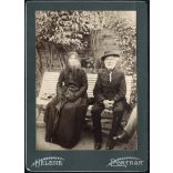 Nagyobb méret, idős elegáns pár magyaros ruhában, monarchia, 1900-as évek. A fotó valószínűleg az Egyesült Államokban készült, és magyar emigránsokat ábrázol. Eredeti kabinetfotó, Helene Portrait. 