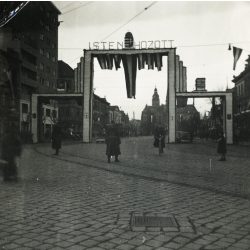   Díszkapu „Isten hozott” felirattal,  Kassa, Felvidék, magyar zászlók, magyar katona,  bevonulás, egyenruha, 2. világháború, Horthy-korszak, helytörténet, Eredeti fotó,  papírkép, felső sarkán gyűrődés.  